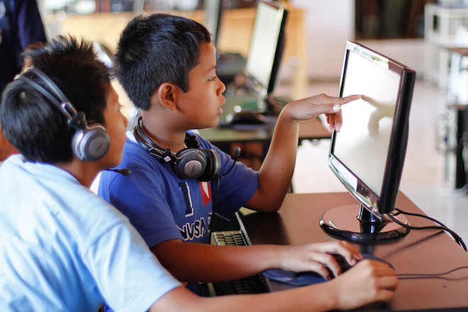 Children using a computer at an Internet cafe in Bali.