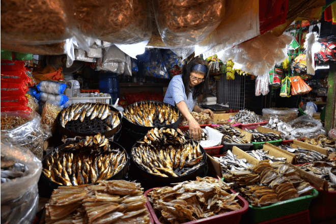 A vendor tends to her her dried fish stall.