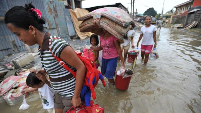 Women and children brave flooded streets.