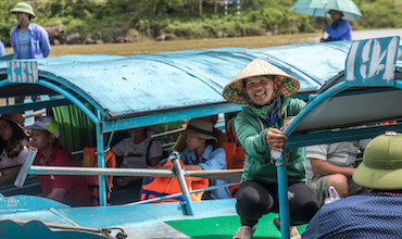 A TOURIST BOAT OPERATOR IN VIETNAM POSES FOR A PICTURE.