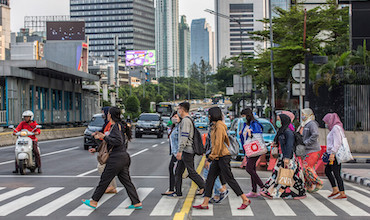 Pedestrians crossing the street in jakarta.