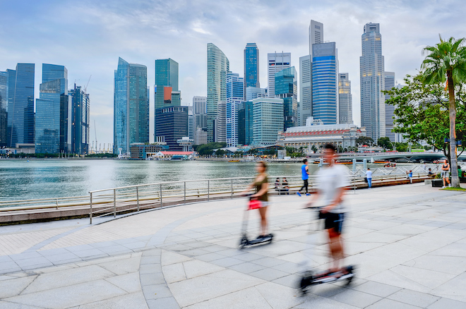People riding an electric scooter in Singapore.