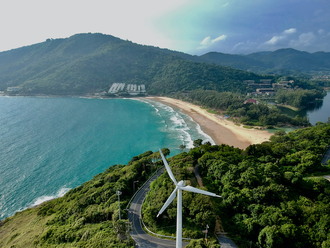 Solar and wind farms are seen by the beach in Thailand.