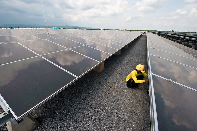 A worker doing maintenance at a solar farm.