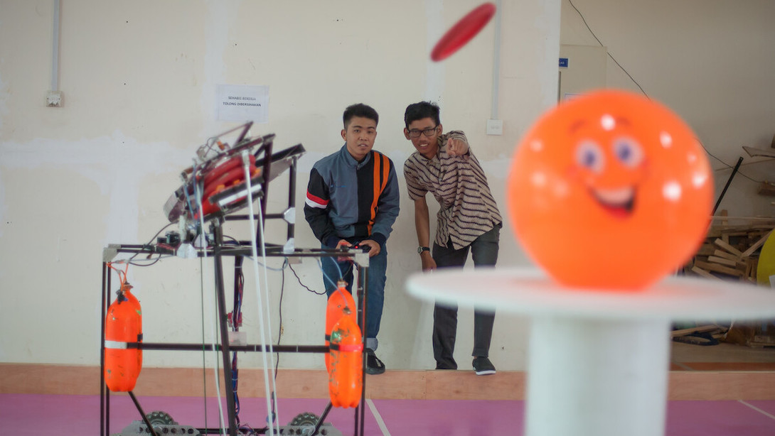 A student and his professor calibrate settings of a frisbee-shooting robot at the Batam State Polytechnic in Indonesia. Photo credit: ADB.