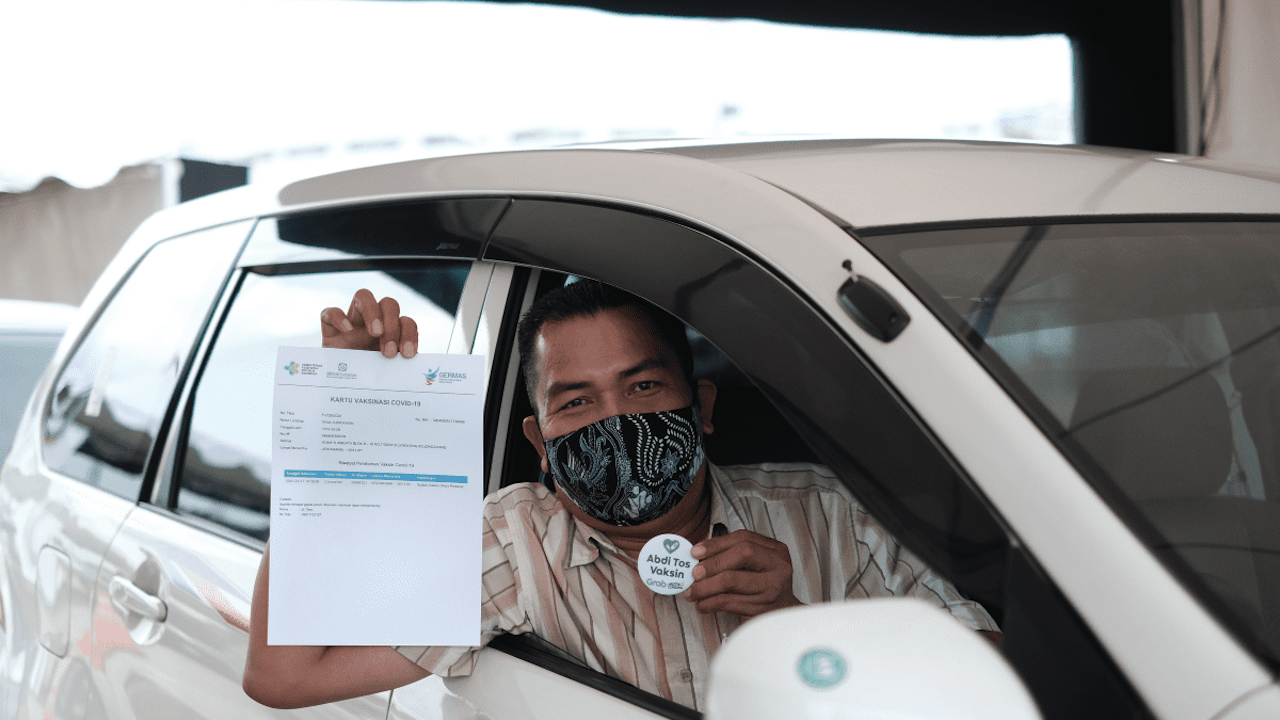 A man showing off a document certifying he received his COVID-19 jab.