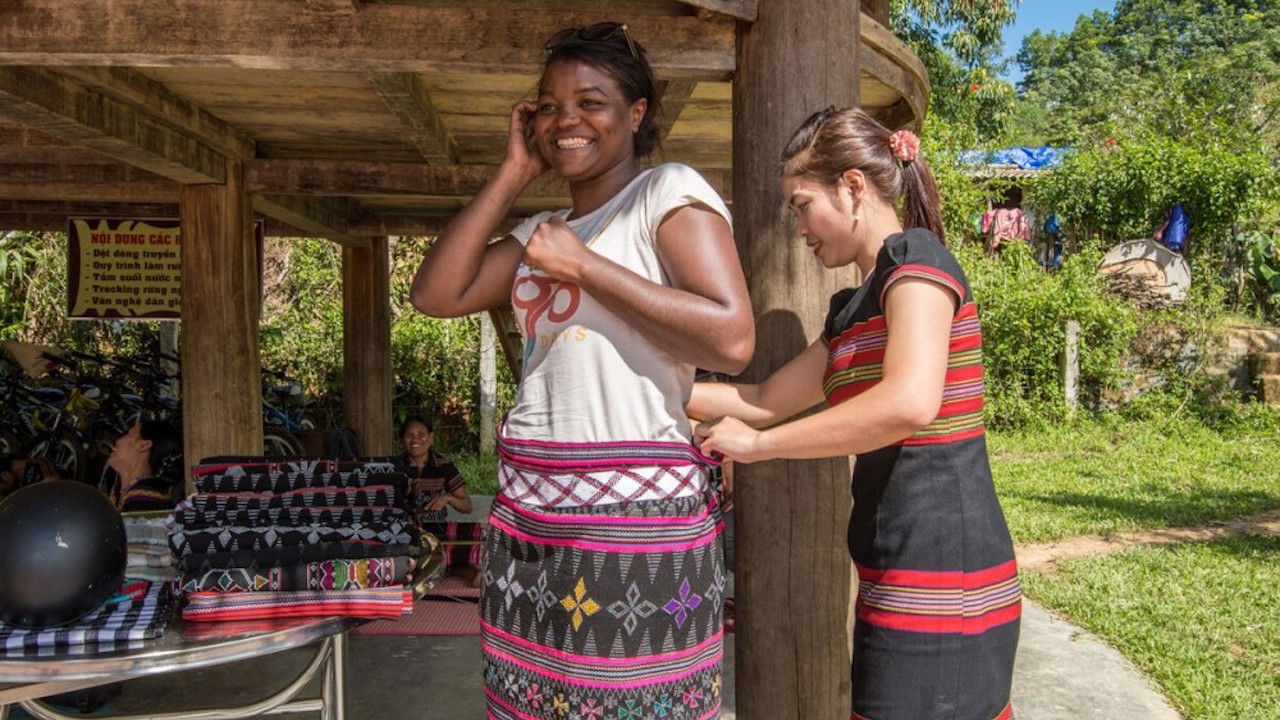 A tourist tries on a traditional Vietnamese handwoven sarong skirt. One of the flagship programs is to promote and support tangible and intangible cultural heritage. Photo credit: ADB.