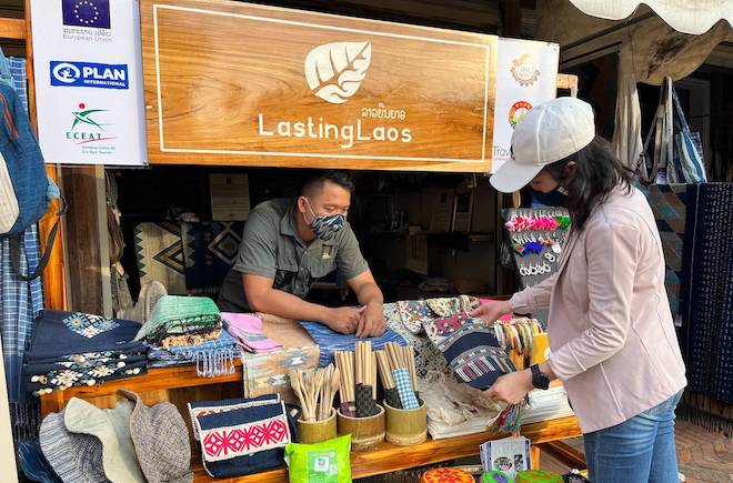 A tourist shops for souvenirs from a stall participating in the SUSTOUR Laos program in Lao PDR.