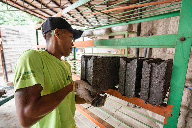 A worker stacking eco-bricks from Green Antz Builders. 