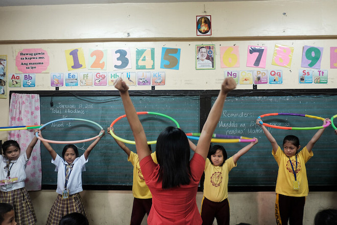A teacher engaging with students in a public school in Manila.