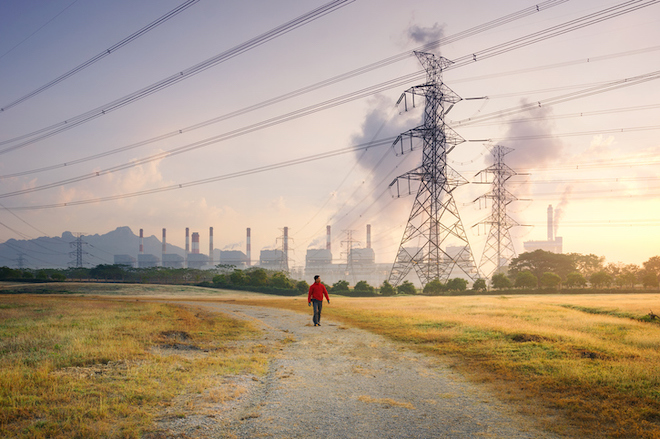 A man walking near a coal power plant in Thailand.