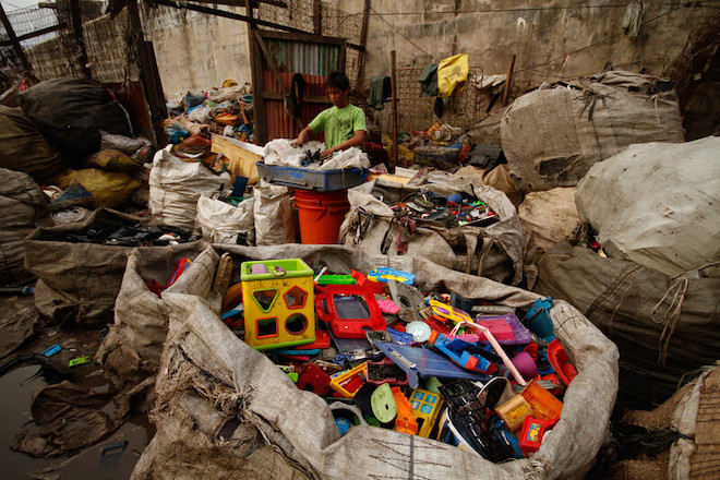 A man sorting wastes at a recycling facility in the Philippines.