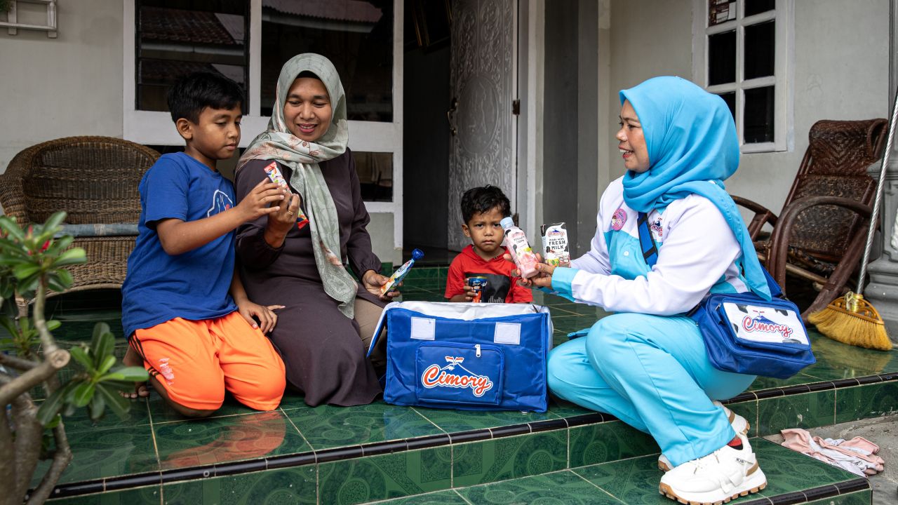 Cultivating customer connections. Miss Cimory sales agent Elmita Sari Dewi delivers dairy products door-to-door, allowing her to build direct relationships with customers while expanding her sales network. Photo credit: Robertus Pudyanto/ADB.