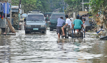 People braving flooded streets in the Philippines after a typhoon hit the country in 2009.