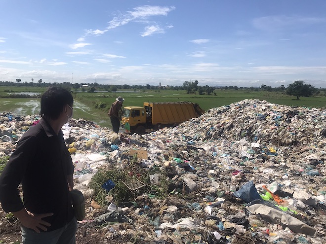 Men milling around a landfill in Battambang. 