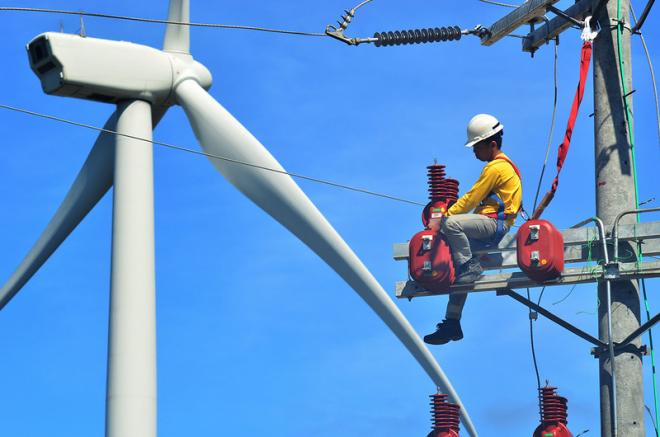 A man does maintenance work on a wind turbine.