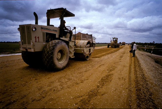 A tractor paving a road in Cambodia