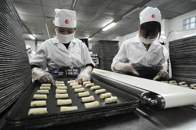 Workers manning the production line at a rice cracker factory in Viet Nam.