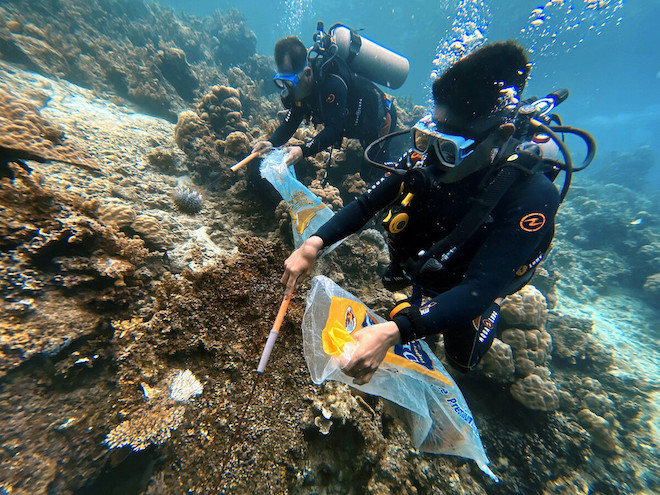 Divers cleaning trash from coral reefs in Palawan.