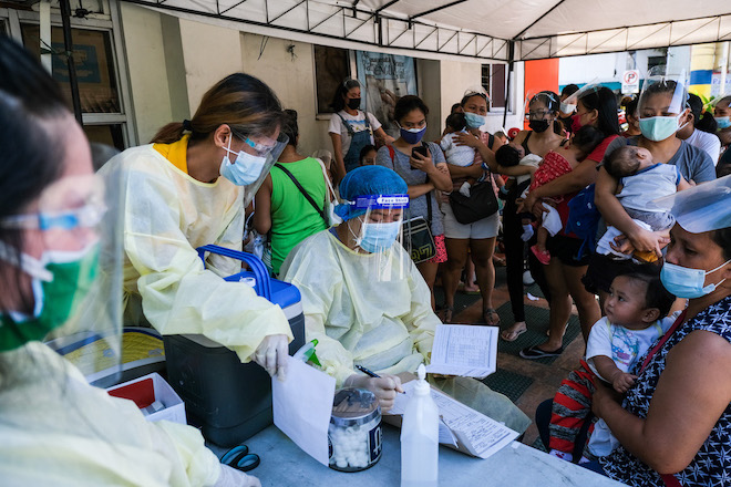People queue to have their babies vaccinated in a health center in the Philippines.