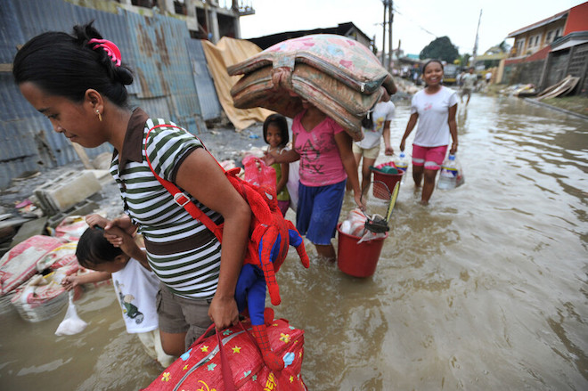 People navigate through flooded streets in the Philippines after a typhoon.