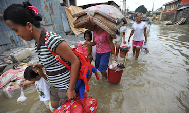 People navigate through flooded streets in the Philippines after a typhoon.