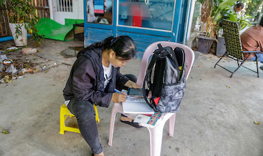 A girl studying with the help of her device.