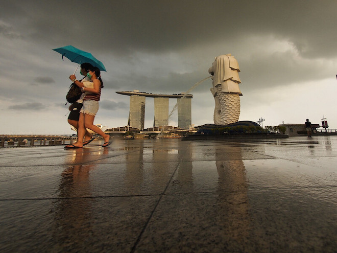 A couple walking near Singapore's famous landmark.