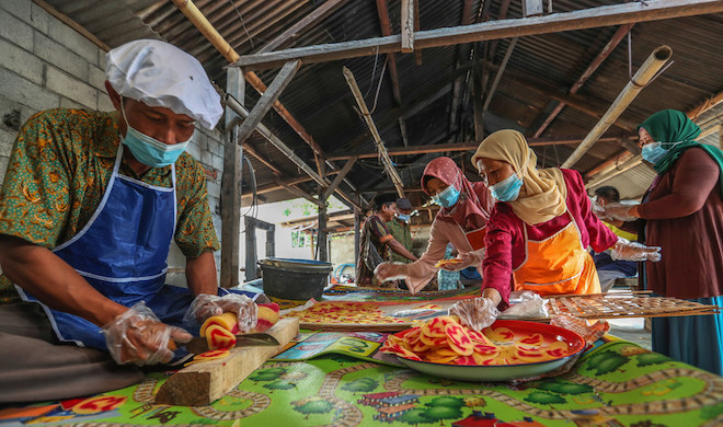 Women training to make cassava chips for their small business.