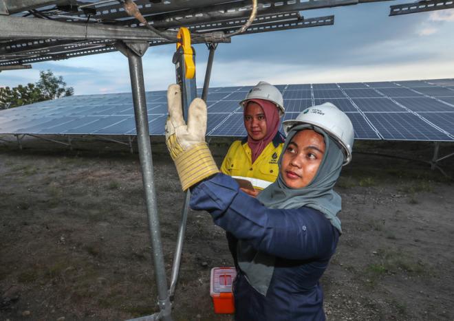 Women working at a solar farm in Indonesia
