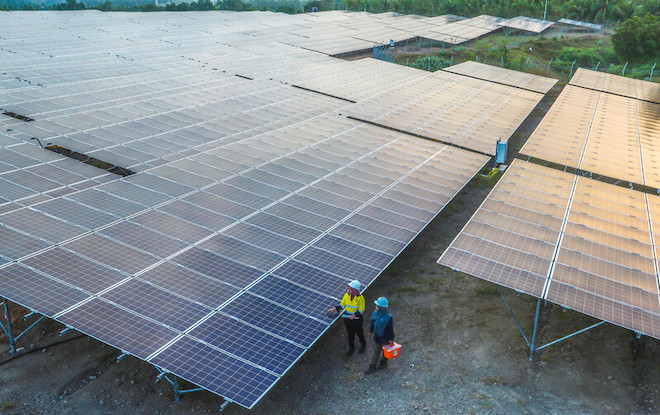 Workers inspect solar panels at a solar farm in Indonesia.