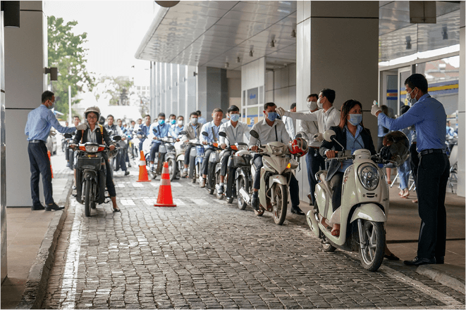 People on motorcycles get through temperature checks.