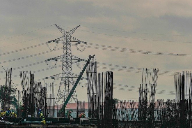 Workers at working beside transmission towers