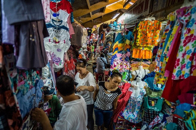 Shoppers browsing through goods at a small clothing store in Viet Nam.