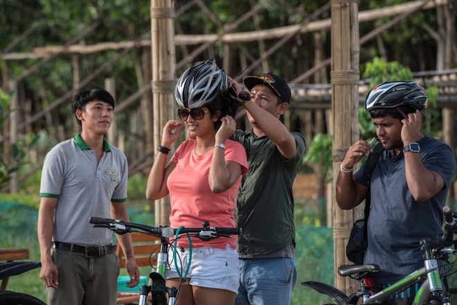 A man helping a woman don a cycling helmet in Viet Nam.