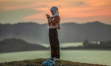 A woman looks at her phone while sightseeing in Indonesia. 