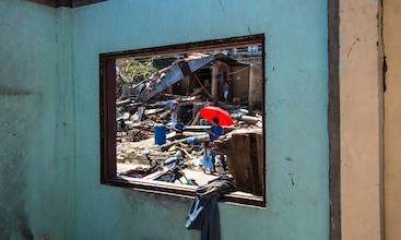 Houses destroyed by typhoon are seen through a window.