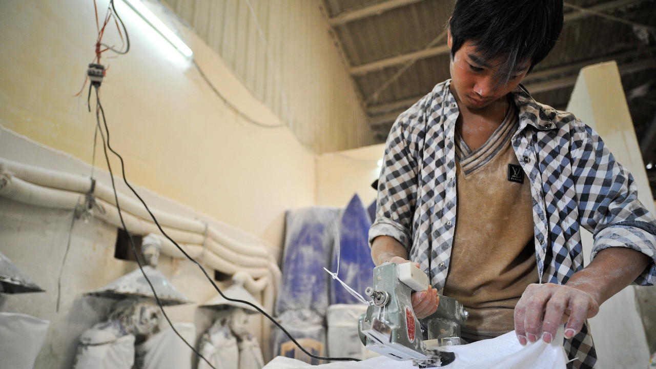 A worker sealing a sack of tapioca starch in a plant in Viet Nam. Photo credit: ADB. 