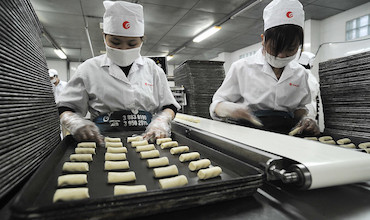 Workers manning the production line at a rice cracker factory in Viet Nam.