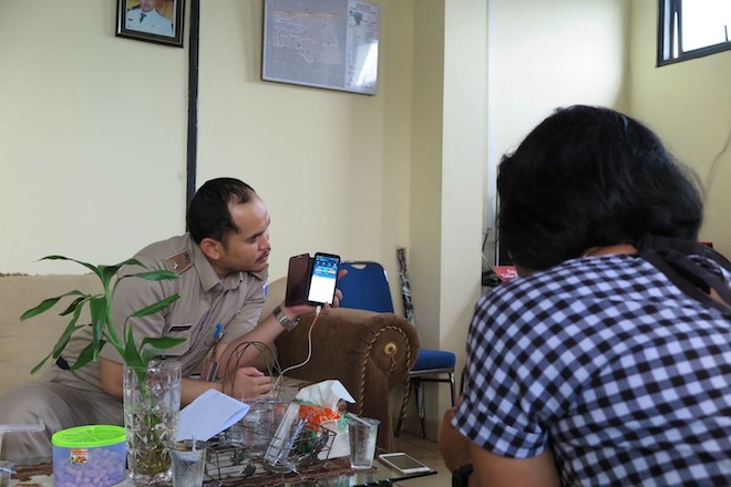 A local government official from Galur subdistrict in Central Jakarta explains the features of a mobile app that he uses for coordination and communication in his daily responsibilities.