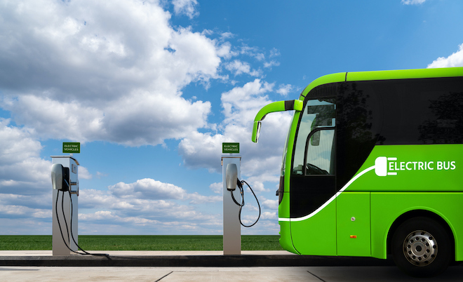 A concept photo of an electric bus parked beside a charging station.