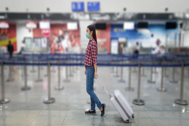 A woman drags her suitcase through an airport.
