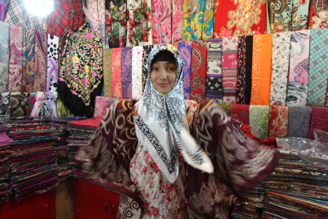 A woman inspecting fabric in a textile store.