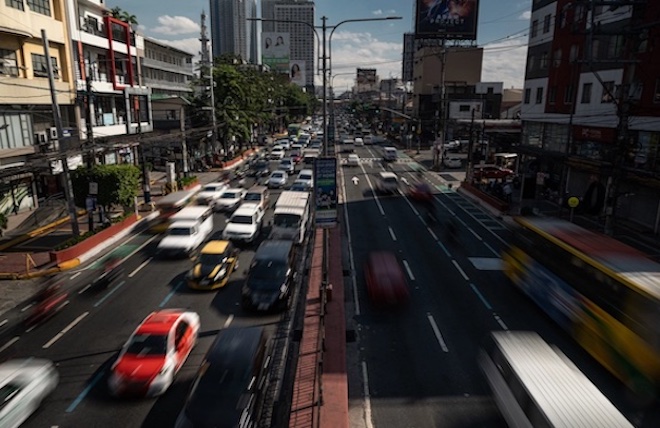 Vehicles passing through a busy road in the Philippines.