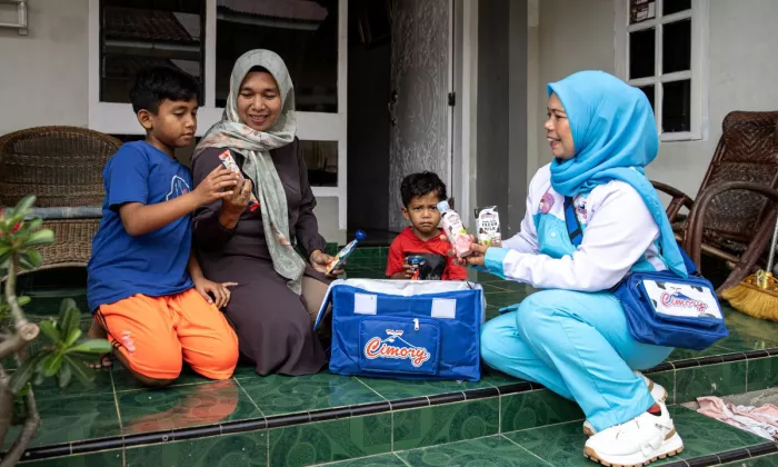 Cultivating customer connections. Miss Cimory sales agent Elmita Sari Dewi delivers dairy products door-to-door, allowing her to build direct relationships with customers while expanding her sales network. Photo credit: Robertus Pudyanto/ADB.