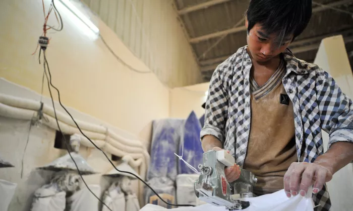 A worker sealing a sack of tapioca starch in a plant in Viet Nam. Photo credit: ADB. 