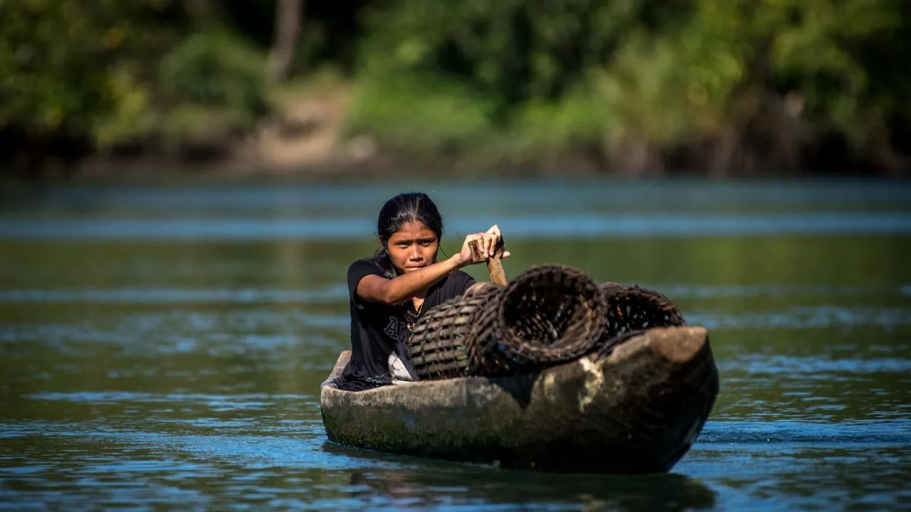 A woman paddles a boat to harvest crabs in Surigao del Norte. Photo credit: ADB.