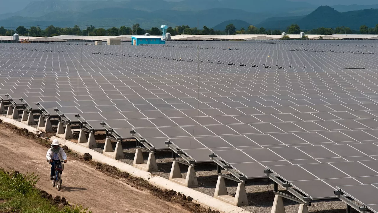 Bicycle rider passes through a solar farm in Southeast Asia. Photo credit: ADB.