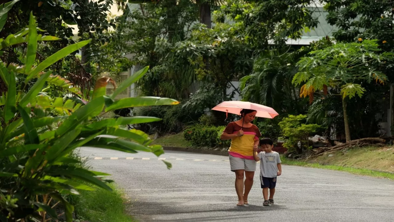 A woman and child walking with an umbrella. Photo credit: ADB.