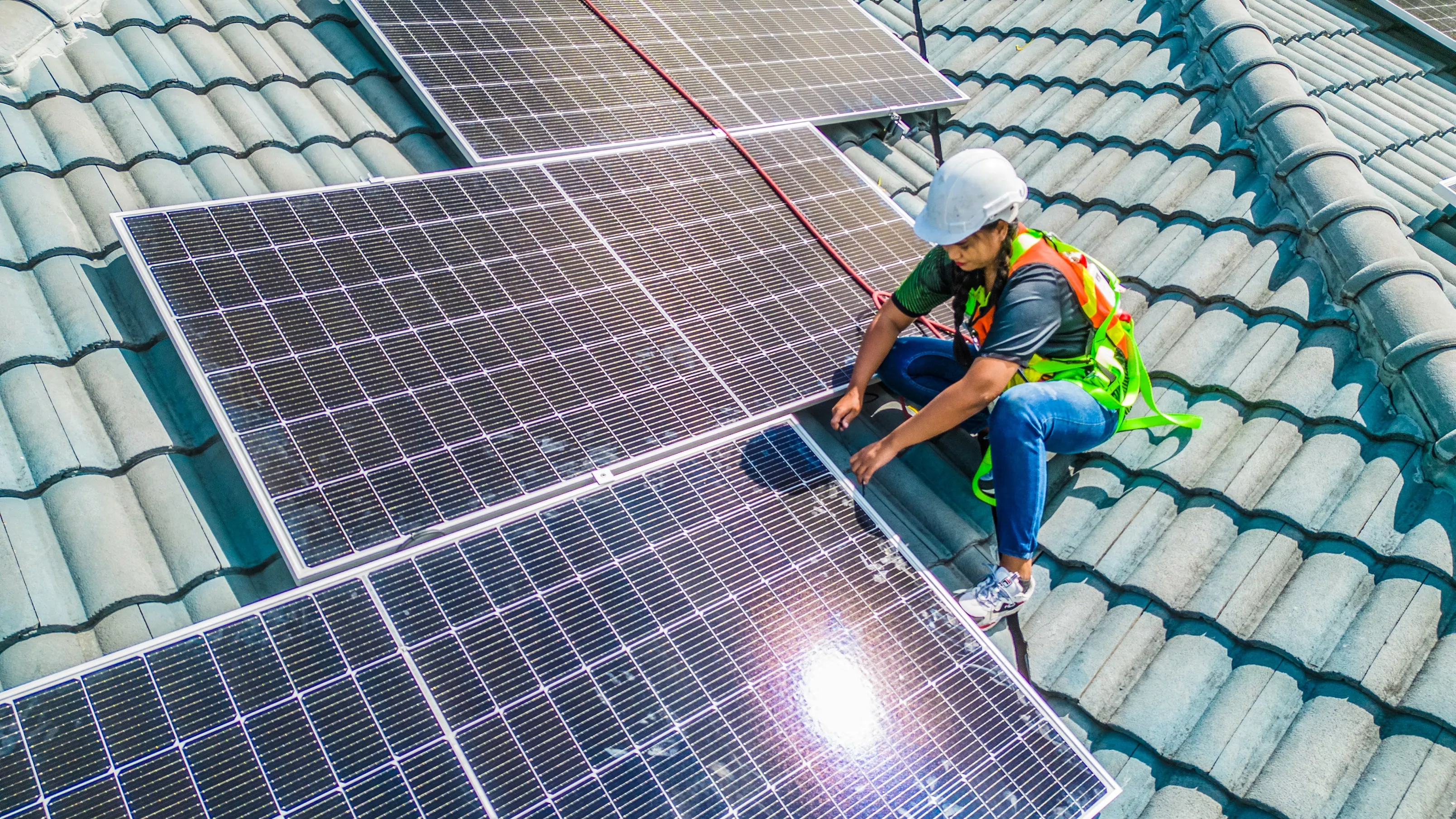 A female solar engineer installs PV panels on the roof. Photo credit: ADB.